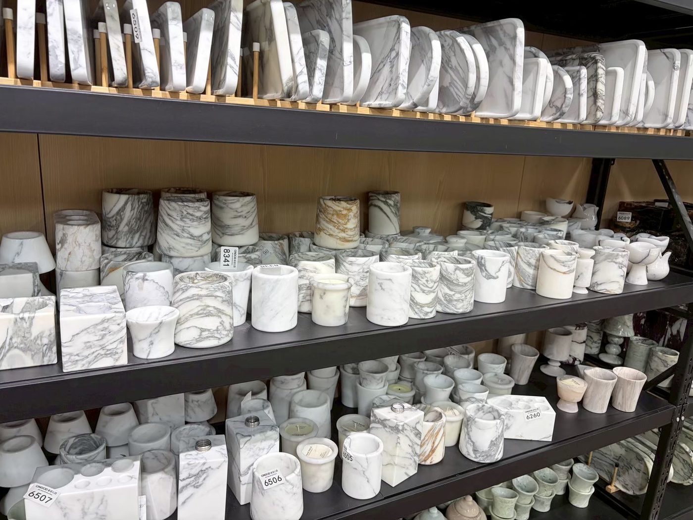 白色系奢石擺件與燭台陳列於展示架上，款式多樣